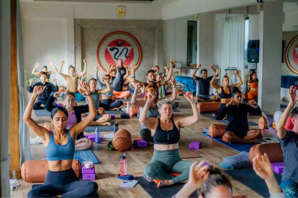 students performing pranayama (breathwork) in class