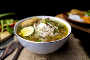 Indonesian turmeric chicken soup, soto ayam, served with fresh herbs in Ubud.